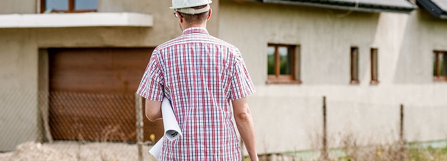 construction worker carrying blueprints