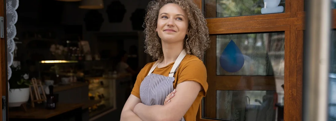Waitress in apron standing outside of cafe and looking around. How to Find the Best Business Insurance in Thompson's Station, Tennessee.