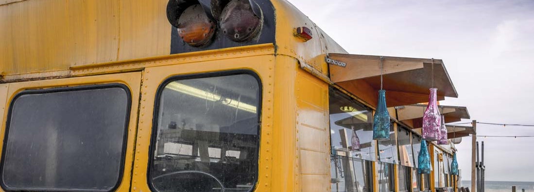 Old american schoolbus turned into beach bar. Find Bus Conversion Insurance.