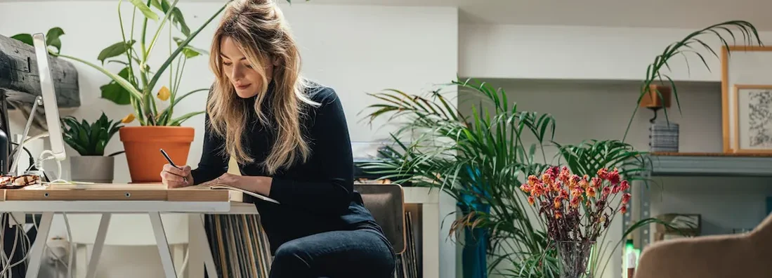 Businesswoman Sitting At Her Desk At Home And Working. How to Write a Business Plan.