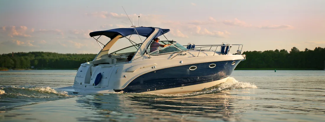 Luxurious motor boat on lake at sunset. Find Boat Insurance Discounts.