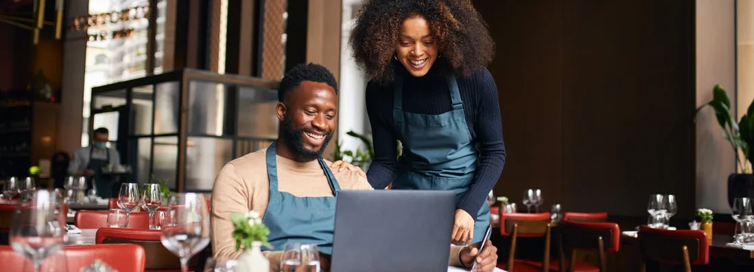 Restaurant managers working with laptop. Find Morrisville, North Carolina business insurance.
