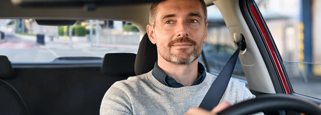 Man driving car and looking in mirror. York, Maine Car Insurance.
