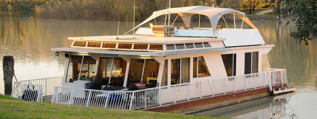 A Houseboat on the river at sunset. Find Houseboat Insurance.