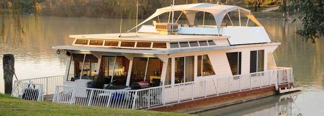 A Houseboat on the river at sunset. Find Houseboat Insurance.