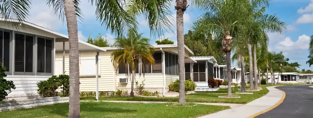 Mobile home park with palm trees and sidewalk. Find Mobile Home Insurance Cost.