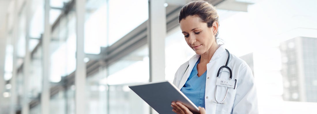 Female doctor using a digital tablet. Find Professional Liability Insurance for Doctors.