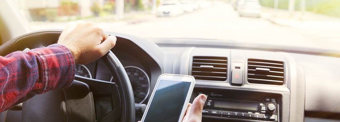 Man using cell phone while driving the car. Distracted Driving Laws in Georgia. 