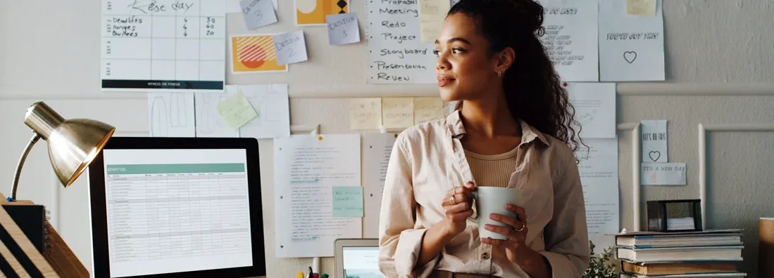 Businesswoman standing while holding a cup of coffee in her office. How to Find the Best Business Insurance in Garden City, New York.