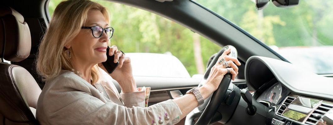 Businesswoman in eyeglasses driving. Find Pittsburgh Pennsylvania car insurance.