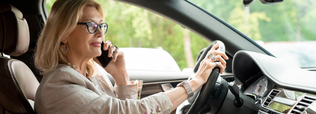 Businesswoman in eyeglasses driving. Find Pittsburgh Pennsylvania car insurance.