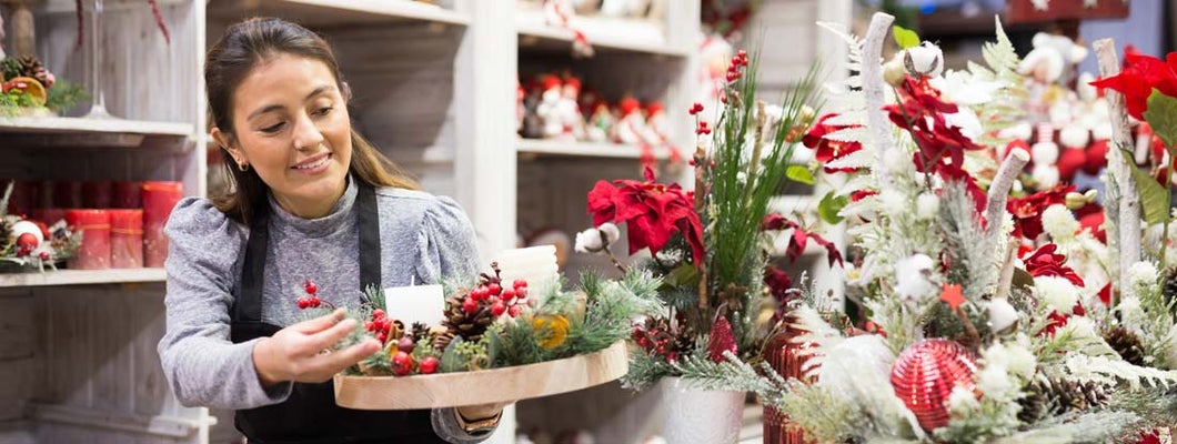 Flower shop worker making christmas compositions. How to prepare your small business for the holidays.