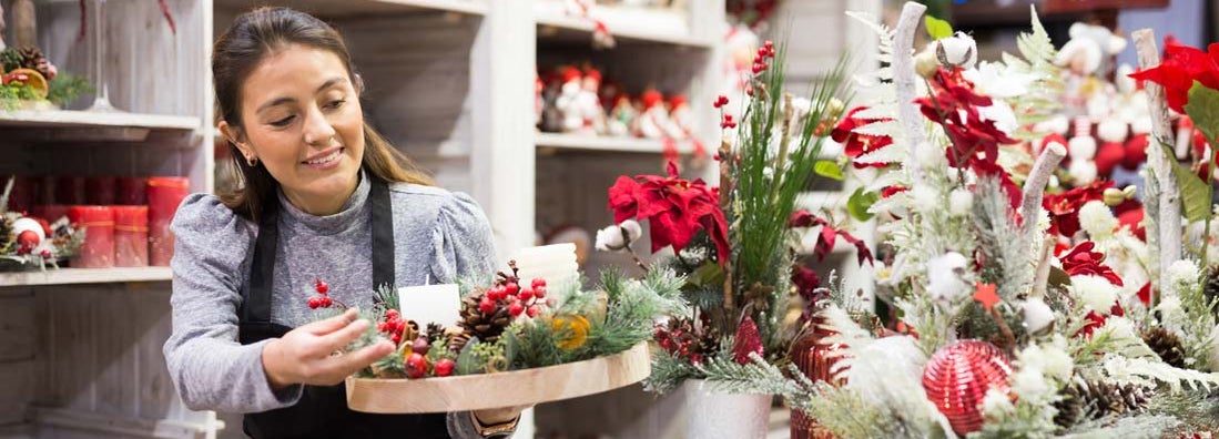 Flower shop worker making christmas compositions. How to prepare your small business for the holidays.