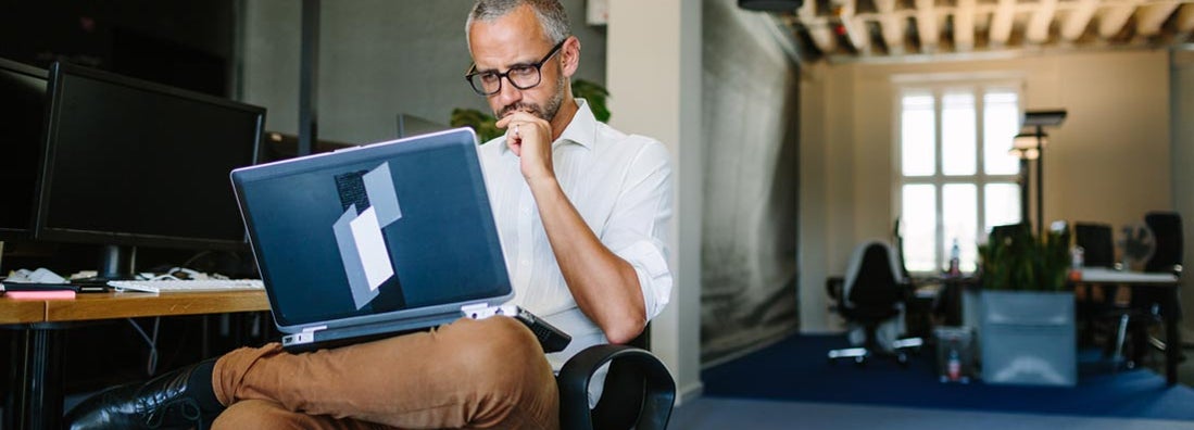 Businessman busy working on laptop. Workers Compensation Exemption.