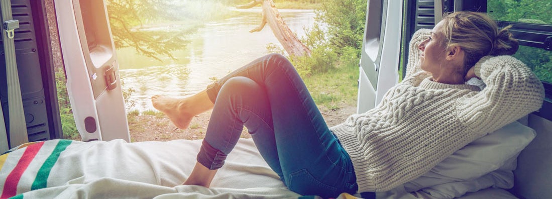 Young woman enjoying a stunning view out of the back of her RV. Find New Jersey RV Insurance.