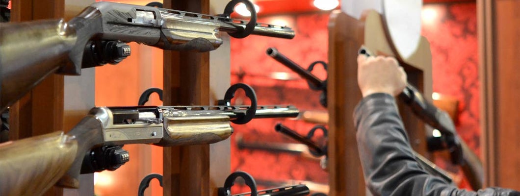 Submachine Gun on the wood wall close-up. Find Gunsmith Insurance.