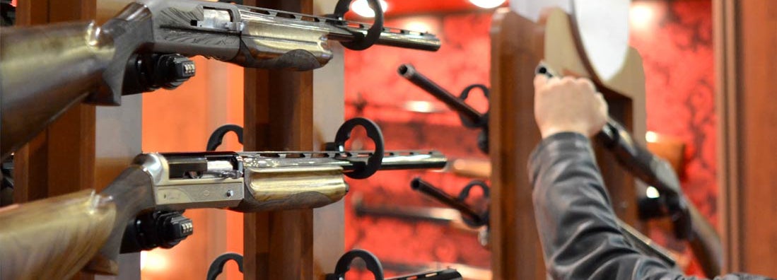 Submachine Gun on the wood wall close-up. Find Gunsmith Insurance.