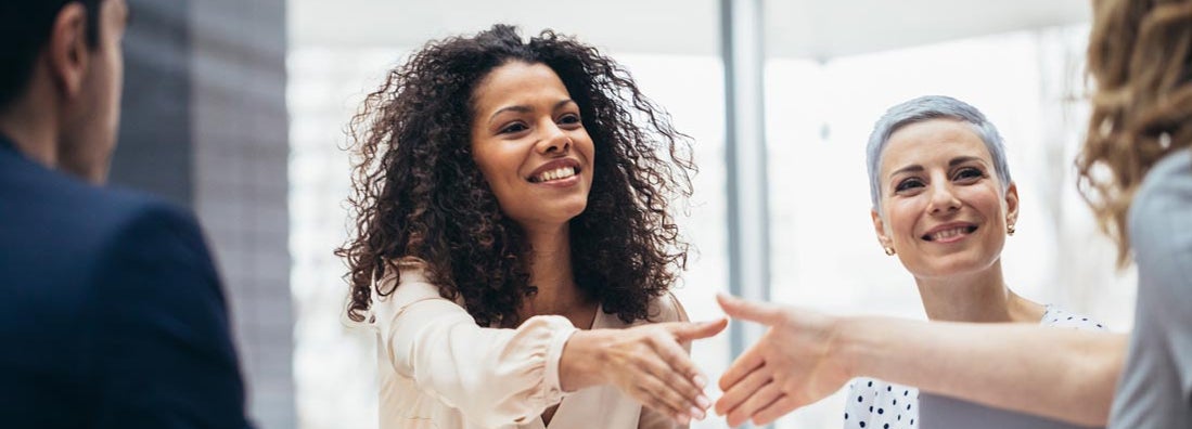 Businesswomen shaking hands with new hire at the office