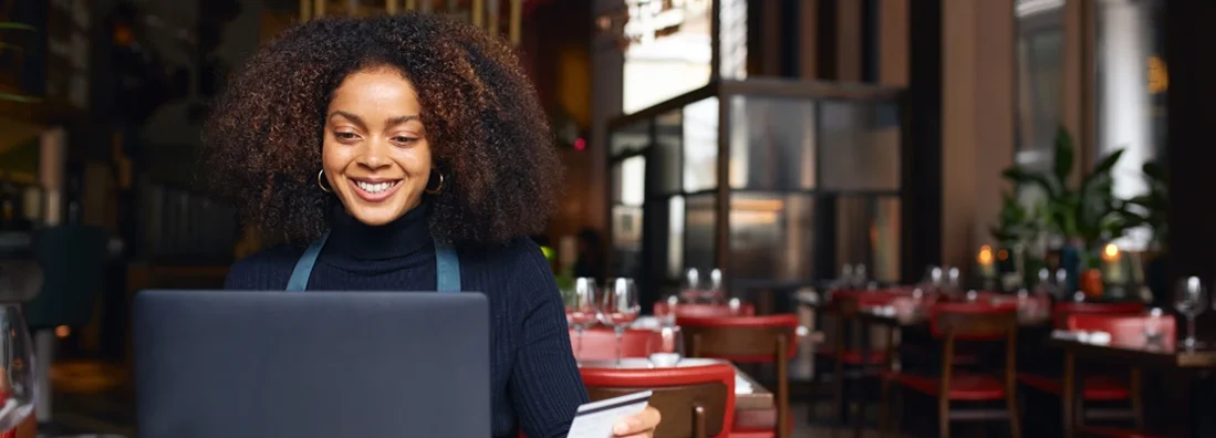 Portrait of restaurant owner using laptop. Business Insurance in Peachtree City, Georgia.
