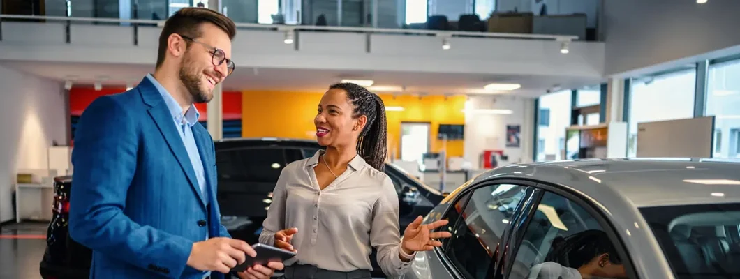 Salesman helping the male customer to choose a new car. 7 Tips To Get the Best Deal On a New Car.