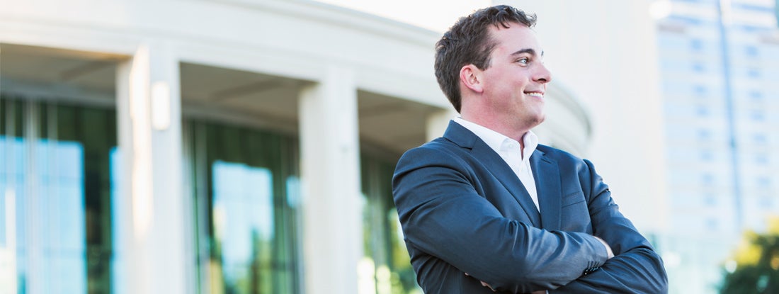 Businessman standing in front of office building.
