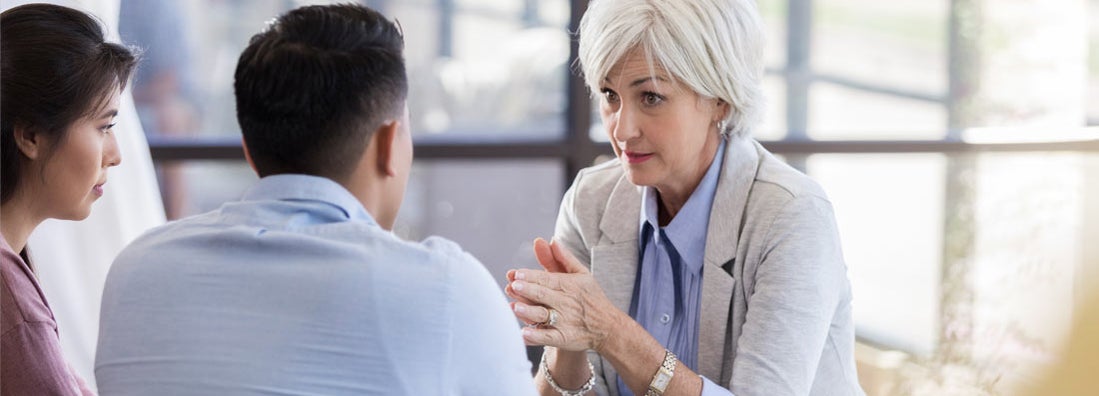 A counselor discusses advice to attentive couple. Find Social Work Malpractice Insurance.