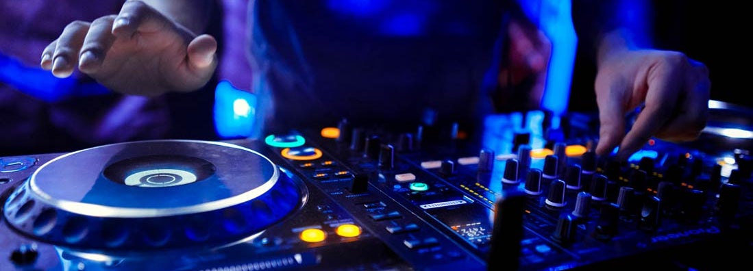 Dj mixes the track in the nightclub at party. Find DJ Insurance.