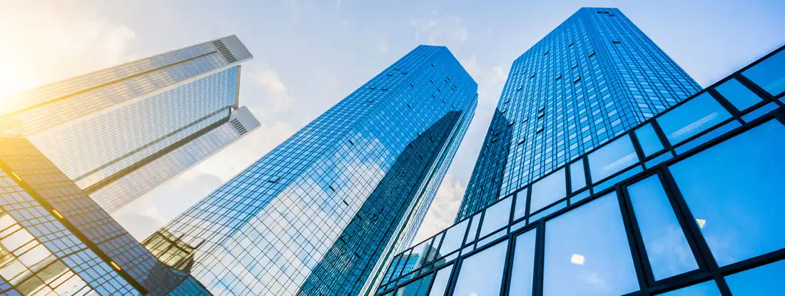 Modern skyscrapers in business district at sunset. How much building insurance is enough?
