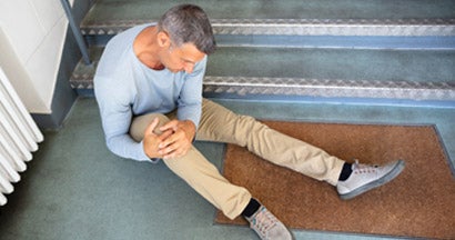 Mature Man Sitting On Staircase After Slip And Fall Accident. If a customer slips and falls at my business who's responsible?