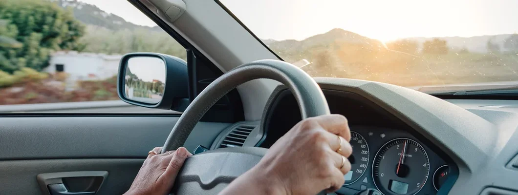 Close up of woman hands driving a car. How to Find the Best Car Insurance Policy in Laramie, Wyoming.