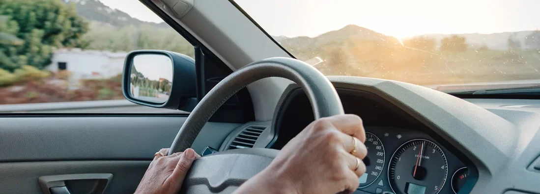 Close up of woman hands driving a car. How to Find the Best Car Insurance Policy in Laramie, Wyoming.