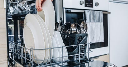 Open dishwasher with clean glasses and dishes close-up. If My Dishwasher Leaks and Floods My Massachusetts Home, Who Pays for the Damage? 