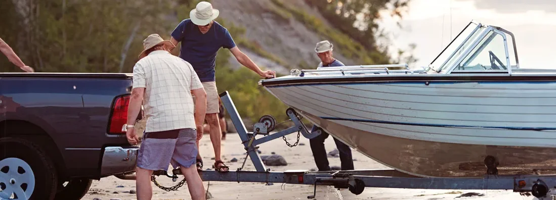 Stacking boat and lashing it onto a trailer. Find Tennessee Trailer Insurance.