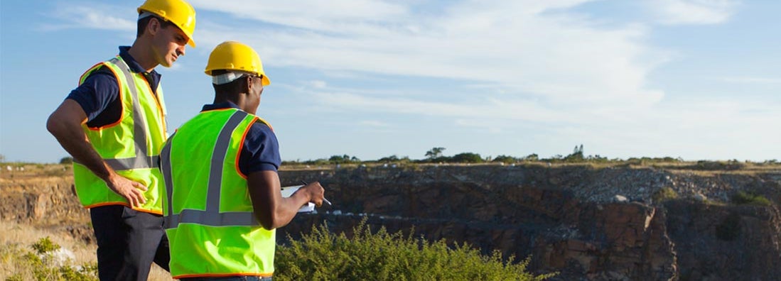 two geophysical surveyors working at mining site