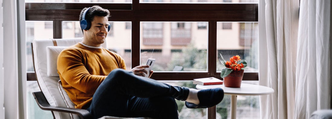 Man with headphones enjoying music in Minnesota condo. Find Minnesota condo insurance.