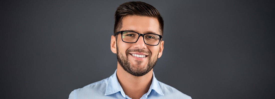 Portrait of contractor standing over dark grey background and looking at camera