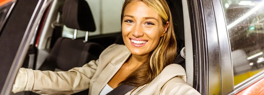 Woman driving in car to work with her arm leaning out of the vehicle during the day. How to Find the Best Car Insurance in Swarthmore, Pennsylvania.