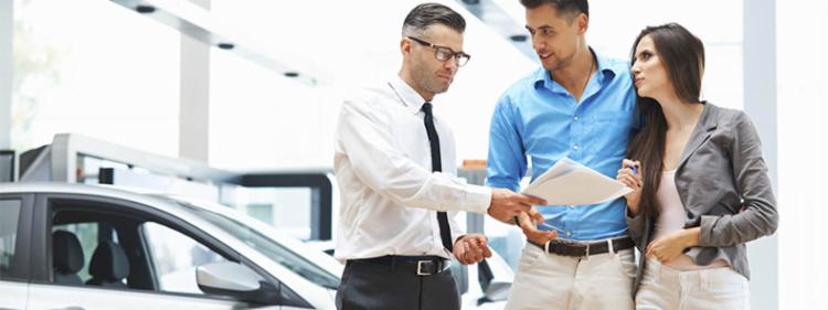 A couple receiving paper work for a rental car.