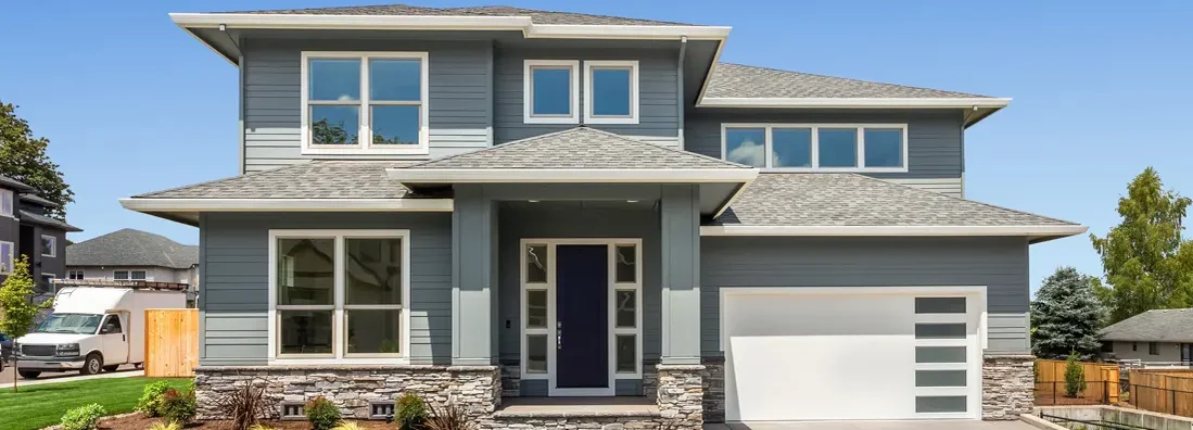 Beautiful suburban home exterior on bright sunny day with green grass and blue sky. Jefferson City, Missouri Homeowners Insurance.