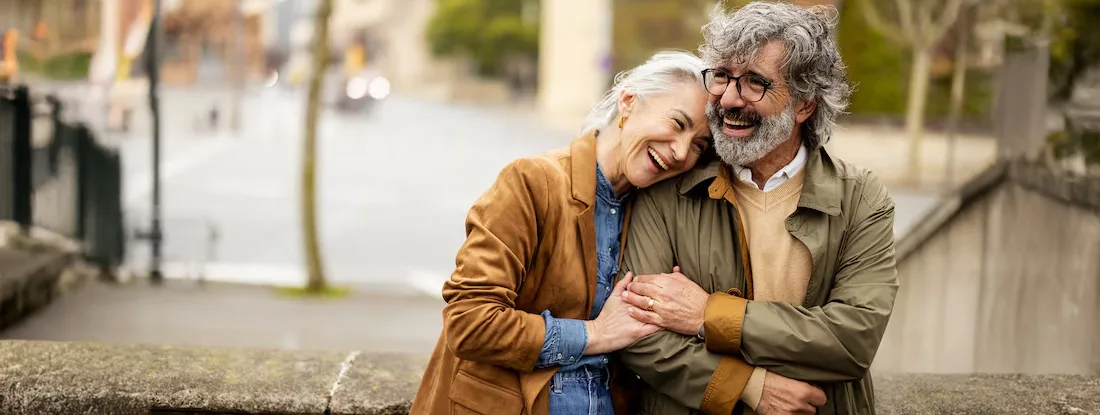 Couple embracing their romantic escape in the urban setting. Find Senior Life Insurance.