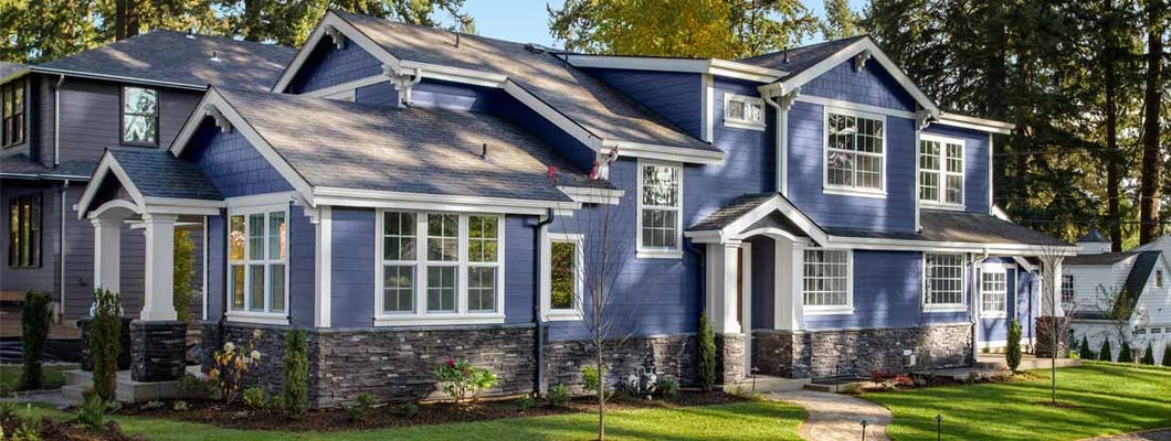 Beautiful home exterior on bright sunny day with green grass and blue sky