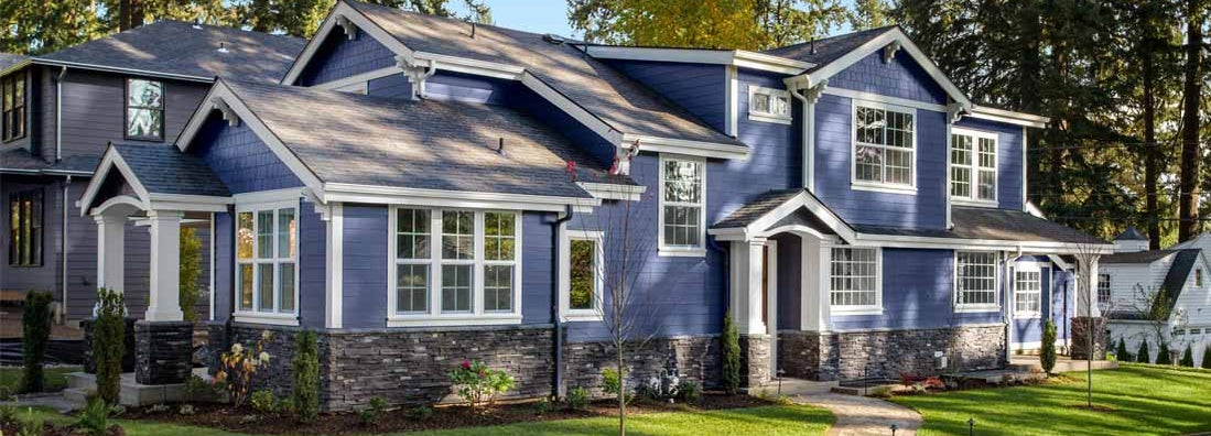 Beautiful home exterior on bright sunny day with green grass and blue sky