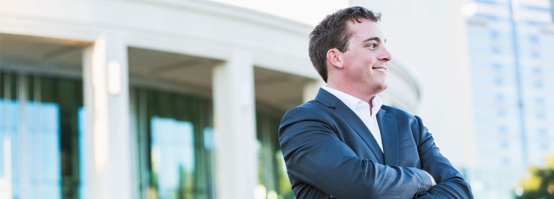Businessman standing in front of office building.