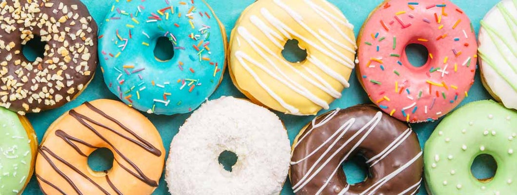 Colorful donuts background. Various glazed doughnuts with sprinkles. Find donut shop insurance.