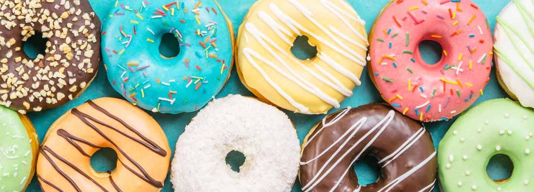 Colorful donuts background. Various glazed doughnuts with sprinkles. Find donut shop insurance.