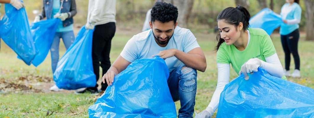 Young couple pick up litter together in public park