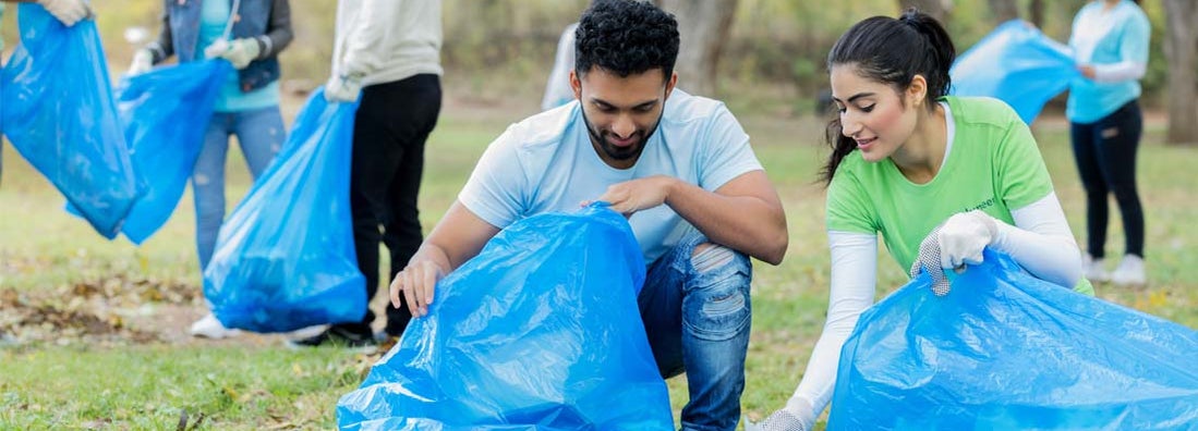 Young couple pick up litter together in public park