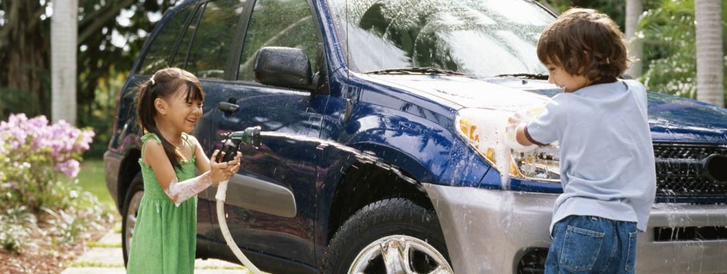 Children washing car on driveway. Find Fresno California car insurance.