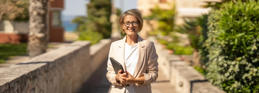 Real estate agent waiting clients in front of of apartments in coastal town. Find Landlord Insurance Cost.