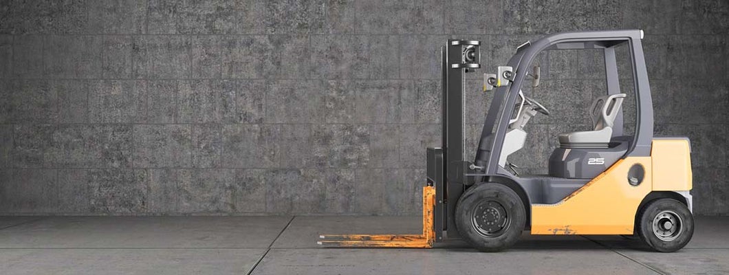Forklift truck standing on industrial concrete wall background. Find Forklift Insurance.